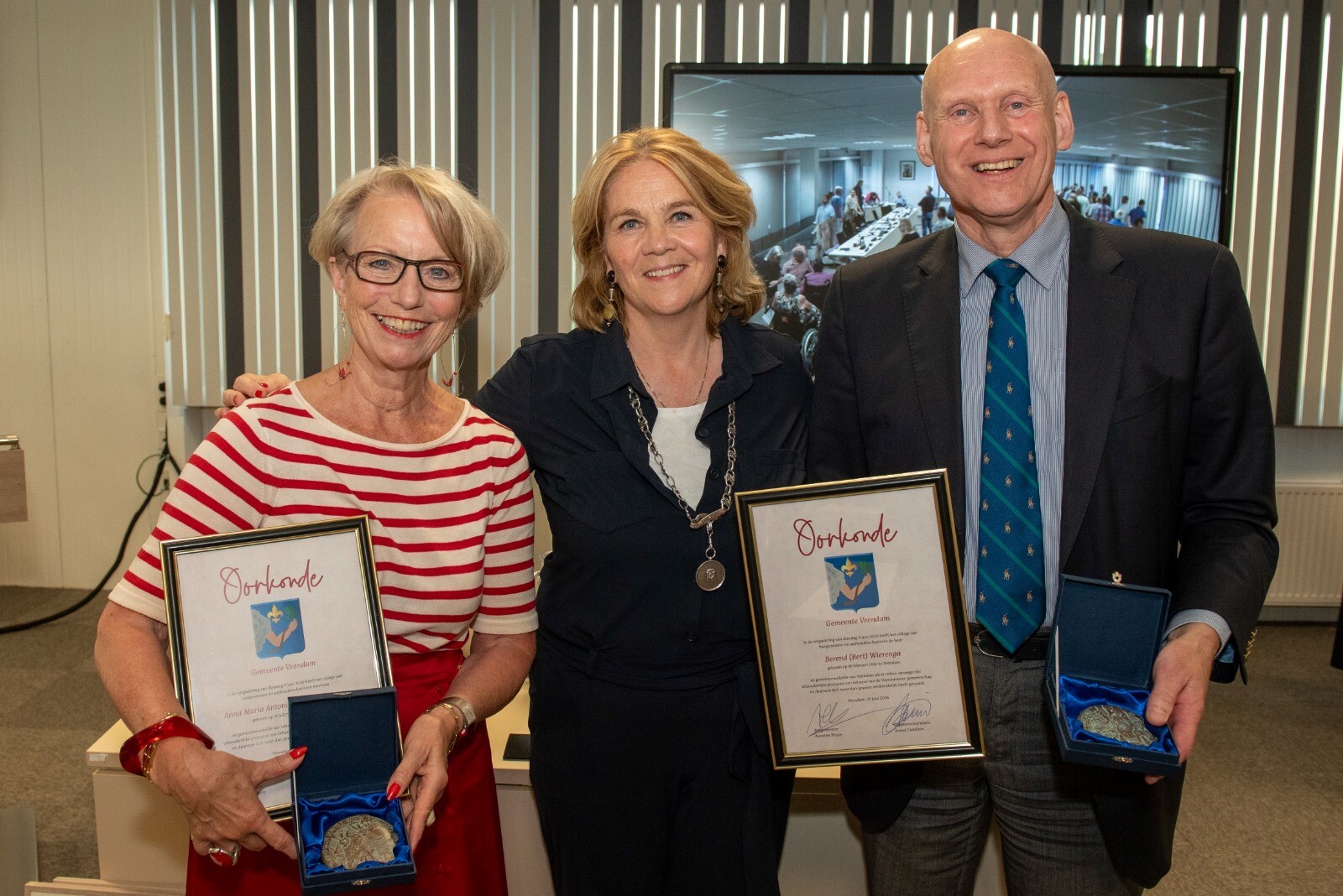 Links vertrekkend wethouder Ans Grimbergen en rechts vertrekkend wethouder Bert Wierenga met de gemeentemedaille   